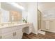 Bathroom with white cabinets, double sinks, framed mirrors, and glass shower at 5460 Lichenhearth Ct, Stone Mountain, GA 30087