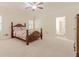 Spacious bedroom with neutral carpet, ceiling fan and traditional wood furniture at 5460 Lichenhearth Ct, Stone Mountain, GA 30087