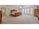 Large bedroom with neutral carpet, several windows, and traditional wood furniture at 5460 Lichenhearth Ct, Stone Mountain, GA 30087