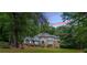 A picturesque Tudor-style home is set among trees with a well-manicured lawn at 5460 Lichenhearth Ct, Stone Mountain, GA 30087