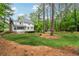 View of the home's backyard with mature trees and expansive lawn at 1275 Mayfield Rd, Milton, GA 30009