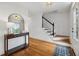 Bright entryway featuring hardwood floors, a staircase with black handrail, and a console table with mirror at 1275 Mayfield Rd, Alpharetta, GA 30009