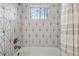 Stylish bathroom with geometric tiled walls, a bathtub and a shower with updated fixtures at 1275 Mayfield Rd, Milton, GA 30009