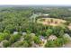 Aerial view of the neighborhood and nearby ballfields, surrounded by mature trees at 725 Danbridge Way, Roswell, GA 30076