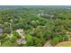 Drone's eye view of houses and mature trees from above, set against the backdrop of a vast forest at 725 Danbridge Way, Roswell, GA 30076