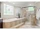 Well-lit main bathroom with a standalone tub, glass shower, and tasteful decor at 725 Danbridge Way, Roswell, GA 30076