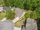 An aerial view shows the home's manicured lawn, mature trees, and circular driveway at 121 Brendylynn Trce, Woodstock, GA 30188