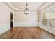 Open-concept dining room featuring hardwood floors, large window and designer chandelier at 121 Brendylynn Trce, Woodstock, GA 30188