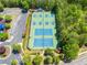 Aerial view of the community tennis courts surrounded by lush landscaping and a nearby parking lot at 121 Brendylynn Trce, Woodstock, GA 30188