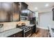 Galley kitchen featuring stainless steel appliances, dark cabinetry, and granite countertops at 2212 Knoxhill Se Vw, Smyrna, GA 30082
