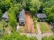 Aerial view of a modern home with a landscaped yard and adjacent vacant lot surrounded by lush greenery at 2438 2Nd Nw St, Atlanta, GA 30318