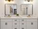 Bathroom featuring double sink vanity, modern light fixtures, sleek decor, and large mirrors at 2438 2Nd Nw St, Atlanta, GA 30318