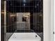 Modern bathtub with a dark tiled wall, matte black fixtures and a handheld shower head at 2438 2Nd Nw St, Atlanta, GA 30318