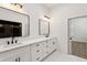 Modern bathroom with dual sinks, matte black faucets, white cabinets and black framed mirrors at 2438 2Nd Nw St, Atlanta, GA 30318