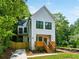 Inviting two-story home with modern farmhouse design, featuring a charming wood porch and lush greenery at 2438 2Nd Nw St, Atlanta, GA 30318