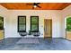 Cozy front porch featuring a ceiling fan, slate flooring, modern furniture, and a view of the wooded surroundings at 2438 2Nd Nw St, Atlanta, GA 30318