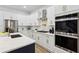 Modern kitchen featuring stainless steel appliances, white cabinets, gold hardware, and a stylish island at 2438 2Nd Nw St, Atlanta, GA 30318