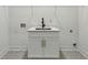 Laundry room with white cabinets and countertop, silver sink and gray patterned floors at 2438 2Nd Nw St, Atlanta, GA 30318