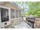 Outdoor seating area and barbeque on a wooden deck next to a screened-in porch and pool at 324 Madeline Way, Temple, GA 30179