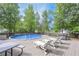 Backyard featuring an above-ground pool surrounded by a wooden deck and lawn chairs at 324 Madeline Way, Temple, GA 30179