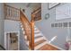 Interior view of staircase with wooden banisters, white risers, and a glimpse of the laundry room at 324 Madeline Way, Temple, GA 30179