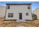 Rear home exterior featuring neutral siding, black trim and a small concrete patio at 7074 Ravenwood Ln, Lithonia, GA 30038