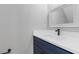 Modern bathroom features a navy blue vanity with white countertop and decorative mirror at 7074 Ravenwood Ln, Lithonia, GA 30038