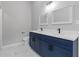 Bathroom featuring double sinks with marble counters and blue cabinets with black hardware at 7074 Ravenwood Ln, Lithonia, GA 30038
