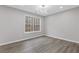 Bright bedroom with LVP flooring and a view of the surrounding trees through a large window at 7074 Ravenwood Ln, Lithonia, GA 30038