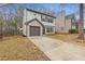 Two-story home with an attached garage, long driveway, and mature landscaping at 7074 Ravenwood Ln, Lithonia, GA 30038