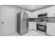 Modern kitchen with stainless steel appliances, white cabinets, and elegant marble-look flooring at 7074 Ravenwood Ln, Lithonia, GA 30038