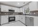 Modern kitchen features stainless steel appliances, white cabinetry, and stylish backsplash at 7074 Ravenwood Ln, Lithonia, GA 30038