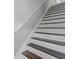 Staircase with freshly painted white risers and stained wooden treads and railing at 7074 Ravenwood Ln, Lithonia, GA 30038