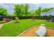 Lush backyard with manicured landscaping, stone benches, and a black fence for added privacy at 123 Woodford Ln, Canton, GA 30115