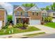 Two-story brick home with a two-car garage and a charming front porch with manicured landscaping at 123 Woodford Ln, Canton, GA 30115