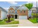 Two-story brick home with an attached two-car garage, manicured lawn, and a charming covered porch at 123 Woodford Ln, Canton, GA 30115