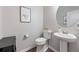 Elegant half bathroom with a pedestal sink, toilet, and stylish decor for a modern touch at 123 Woodford Ln, Canton, GA 30115