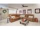 Comfortable living room features a large sectional sofa, ceiling fan, and unique barn door detail at 164 Inwood Walk, Woodstock, GA 30188
