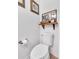 Toilet with a shelf and artwork above it in a bathroom with wood-look flooring at 3501 Great Sky Pkwy, Canton, GA 30114