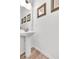 Pedestal sink bathroom with three art pieces and wood-look flooring at 3501 Great Sky Pkwy, Canton, GA 30114