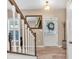 Bright foyer featuring wood-look floors, a staircase, and a front door with a decorative wreath, creating a welcoming entrance at 3501 Great Sky Pkwy, Canton, GA 30114