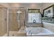 Elegant bathroom with a glass shower, soaking tub, and ornate window design at 4485 Cadmium Dr, Cumming, GA 30040