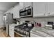 Close-up of kitchen featuring stainless steel appliances, white cabinetry, and stylish countertops at 4485 Cadmium Dr, Cumming, GA 30040