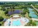 Community outdoor pool features a large pool area, slides, ample seating, and lovely landscaping with a neighborhood lake at 4485 Cadmium Dr, Cumming, GA 30040