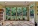 Bright sunroom showcasing tile flooring, large windows, and tranquil views of the landscaped backyard at 4485 Cadmium Dr, Cumming, GA 30040