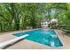 Backyard in-ground pool with diving board surrounded by mature trees and a well-maintained deck at 800 Breckinridge Sw Rd, Marietta, GA 30064