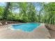 Backyard in-ground pool surrounded by mature trees and a well-maintained concrete deck at 800 Breckinridge Sw Rd, Marietta, GA 30064