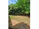 View of a backyard with grassy area and some trees and bushes at 1150 Hillary Ln, Lawrenceville, GA 30043