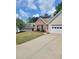 Exterior view of a home with a well-manicured lawn and a paved driveway leading to the garage at 1150 Hillary Ln, Lawrenceville, GA 30043