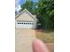 Attached garage with a white door and a concrete driveway, next to lush greenery at 1150 Hillary Ln, Lawrenceville, GA 30043